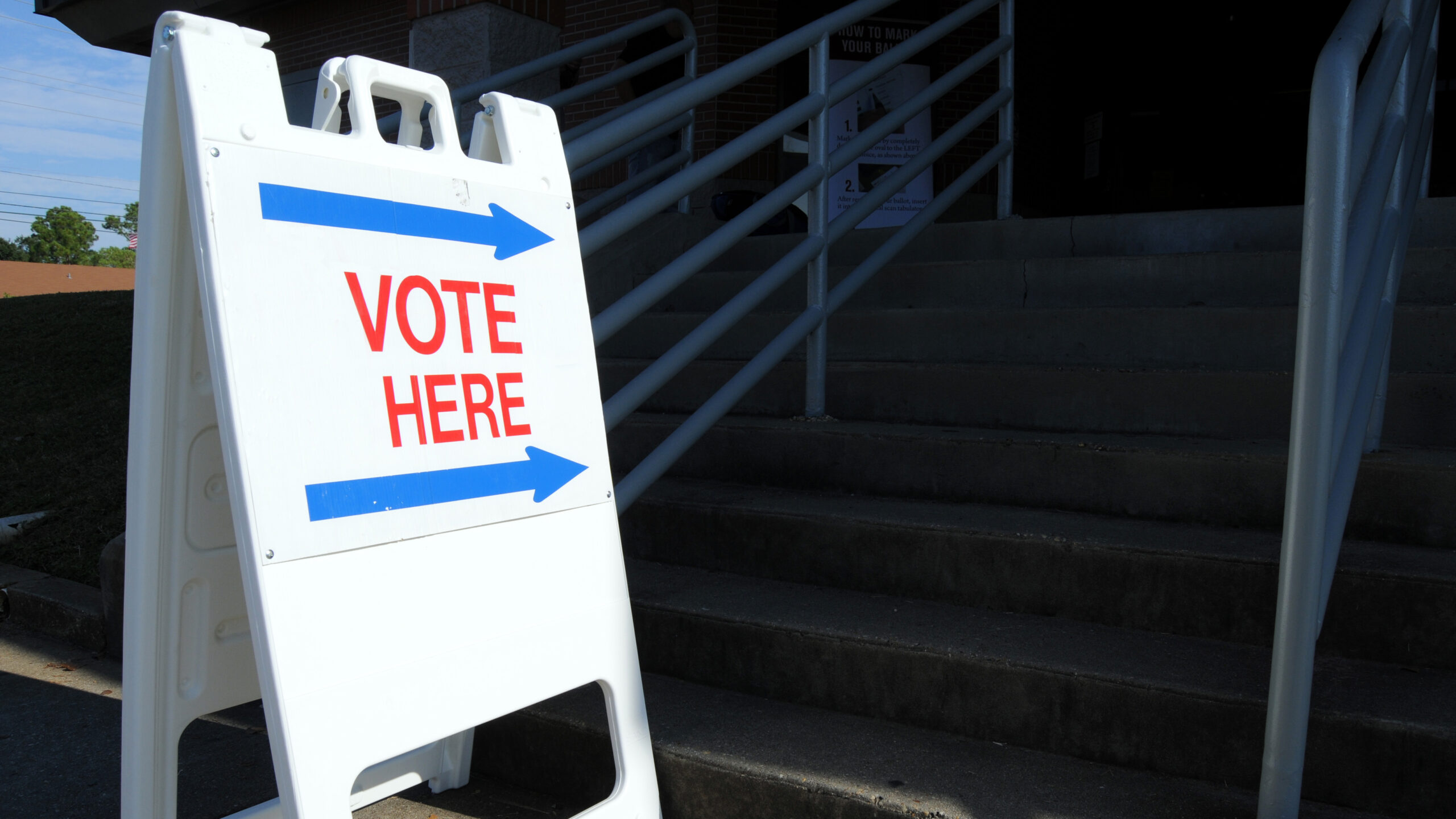 A Vote Here sign leading to a set of stairs.