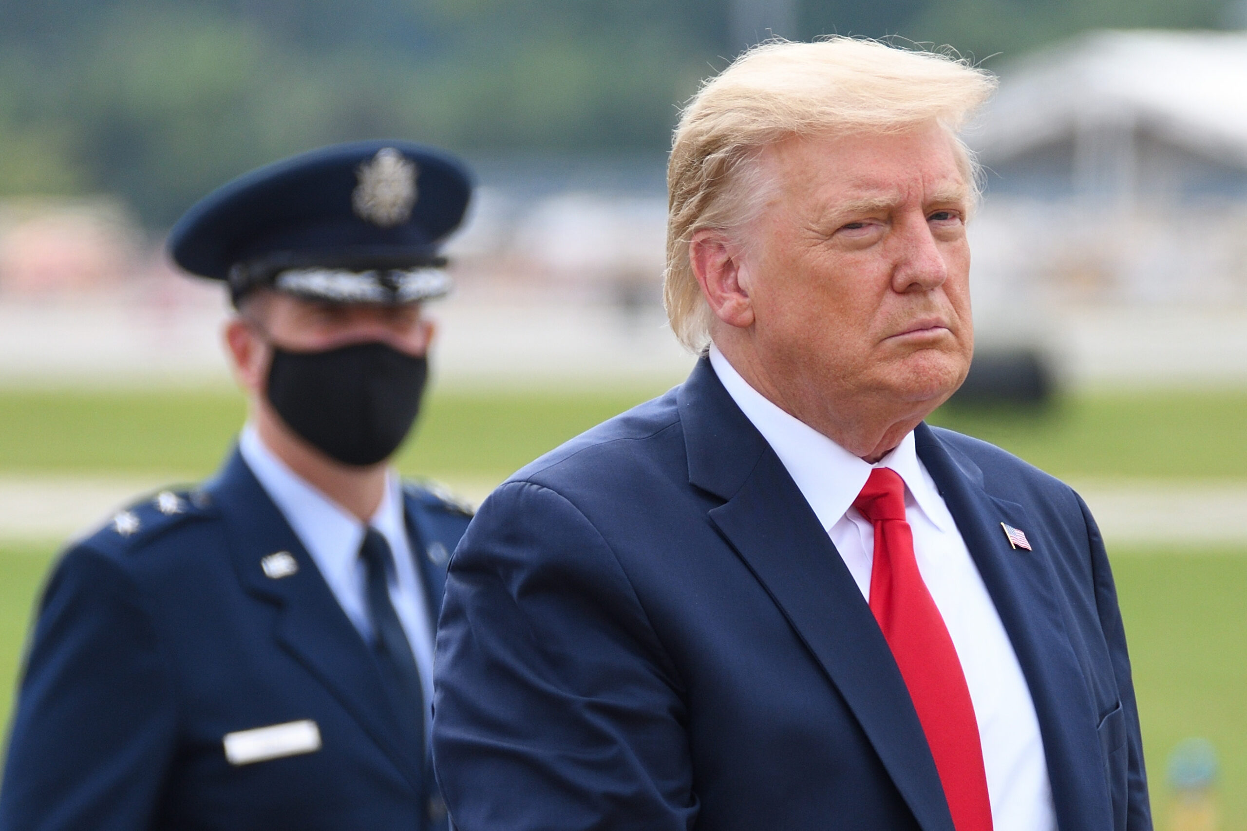 Trump with a US army officer in the background.