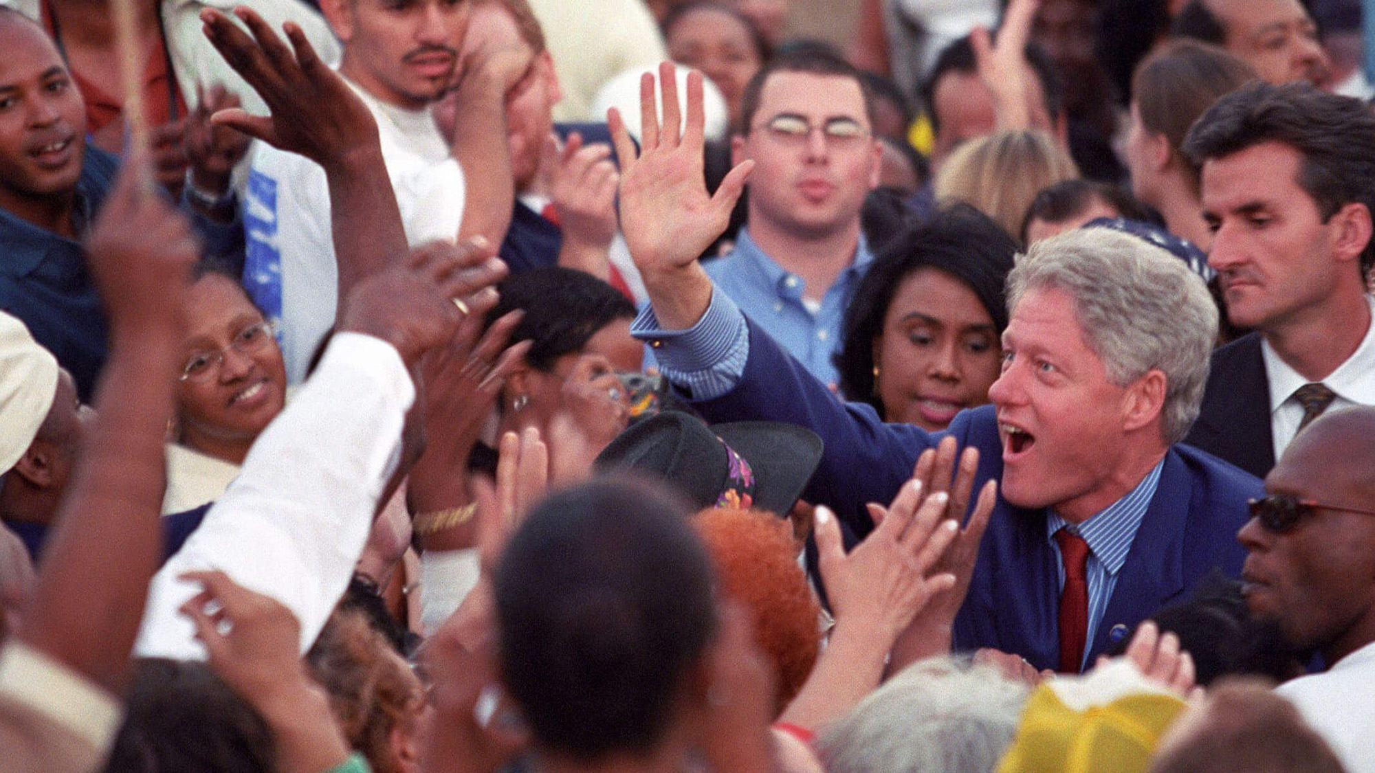 Bill Clinton giving supporters a high five.