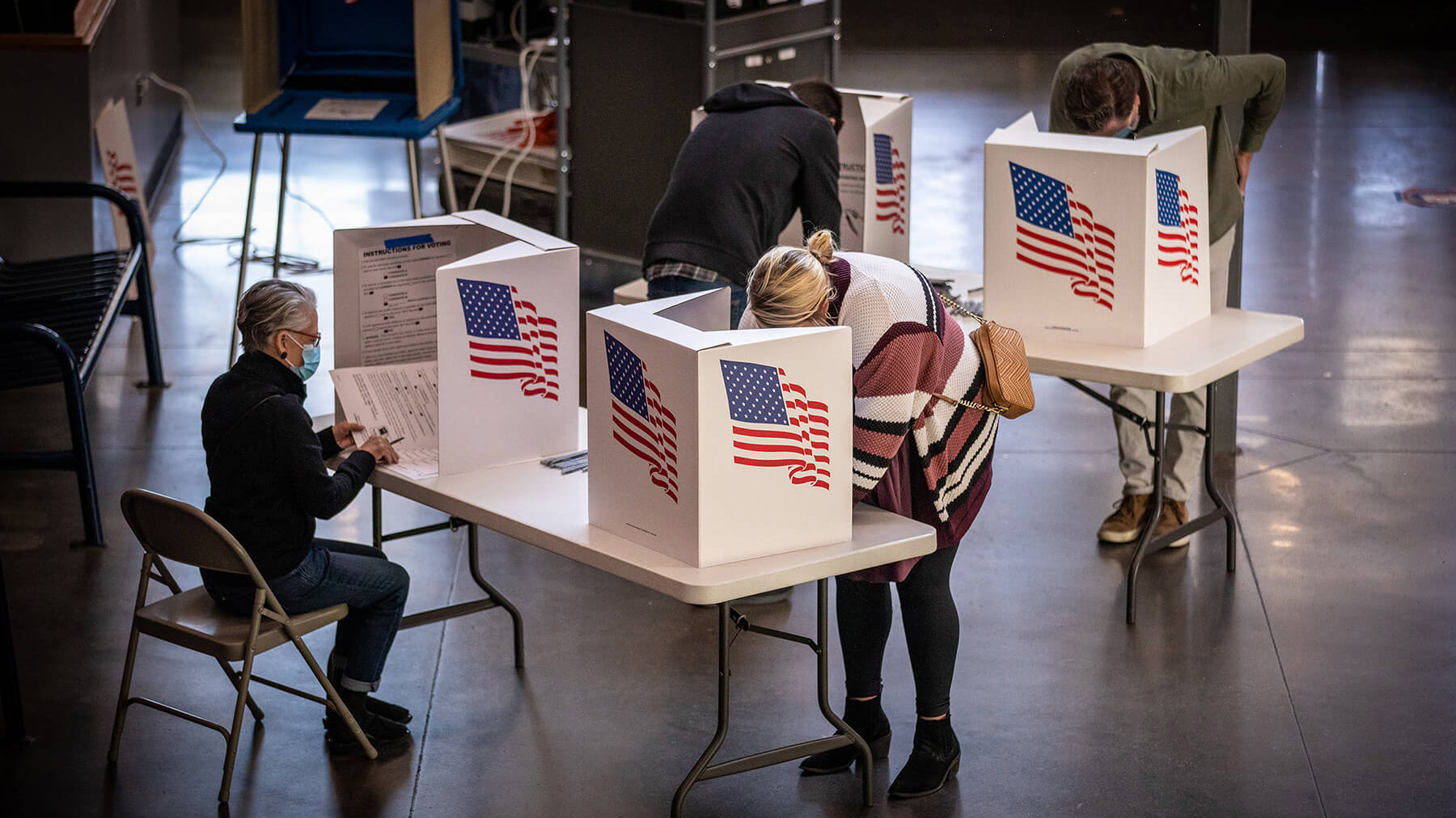 Several people voting in booths.