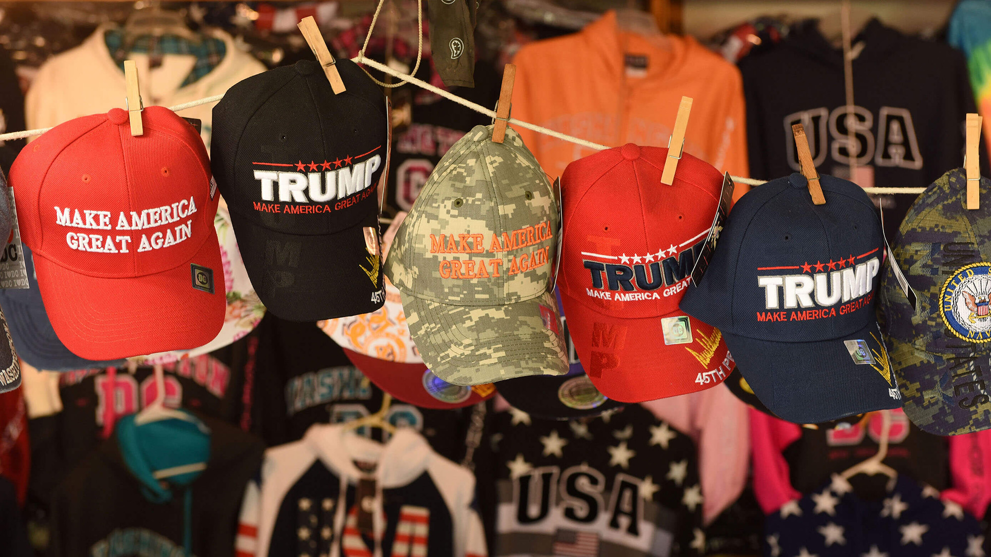 Trump hats hanging on a clothesline.