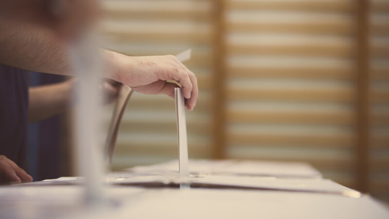 A hand casting a ballot.