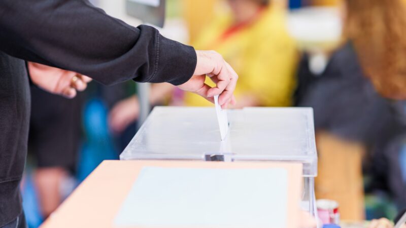 A hand casting a ballot.