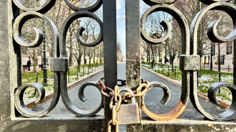 locked university gate represents constraints on free speech and academic freedom