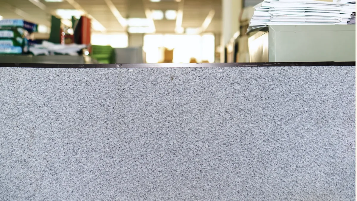 A cubicle with office above it in the background. 
