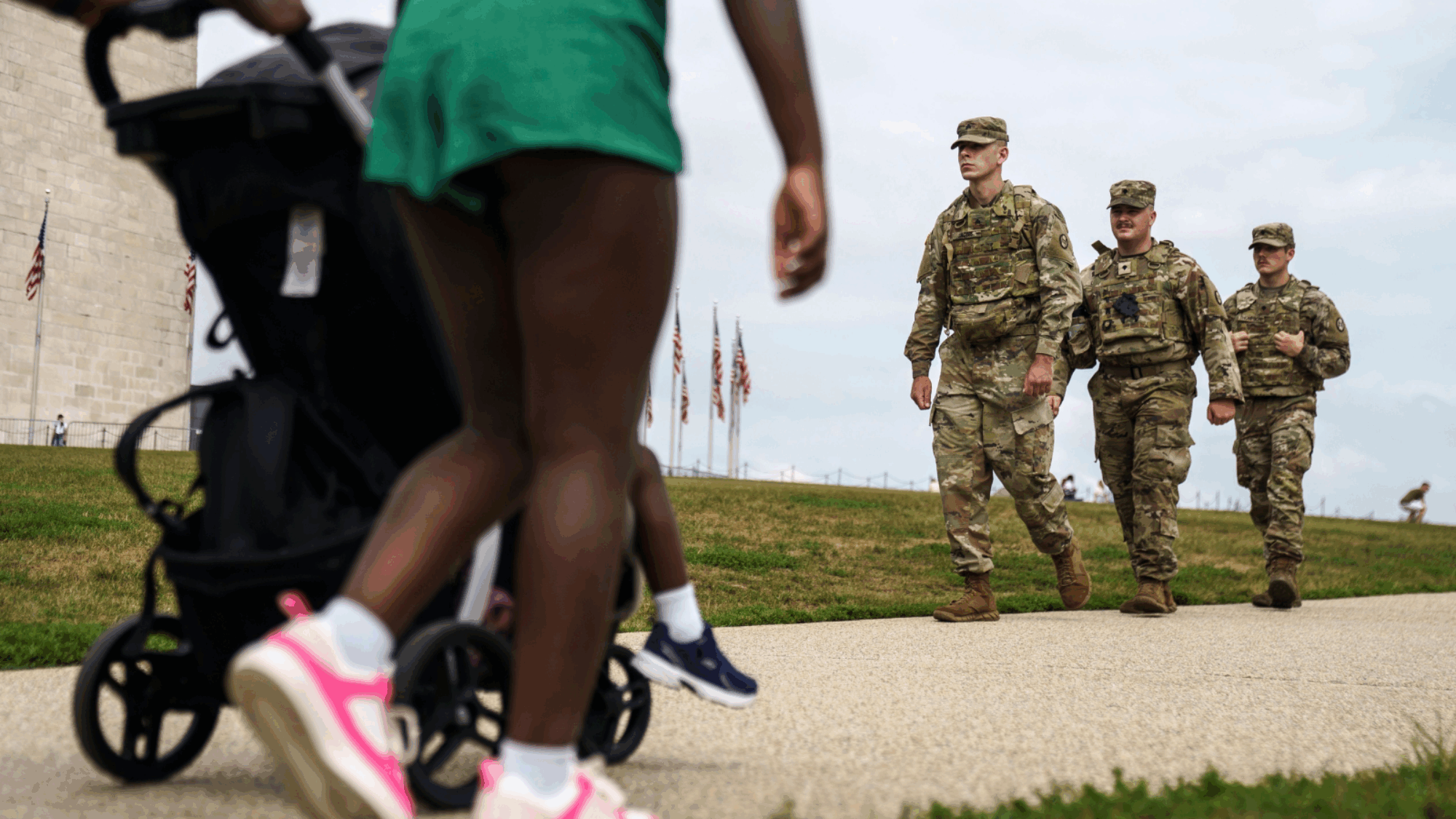 People walking with a stroller passed members of the National Guard.
