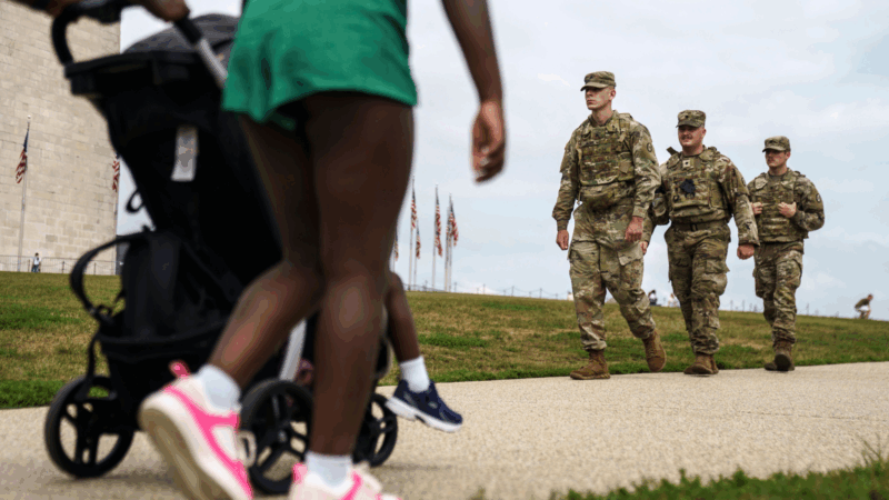 People walking with a stroller passed members of the National Guard.
