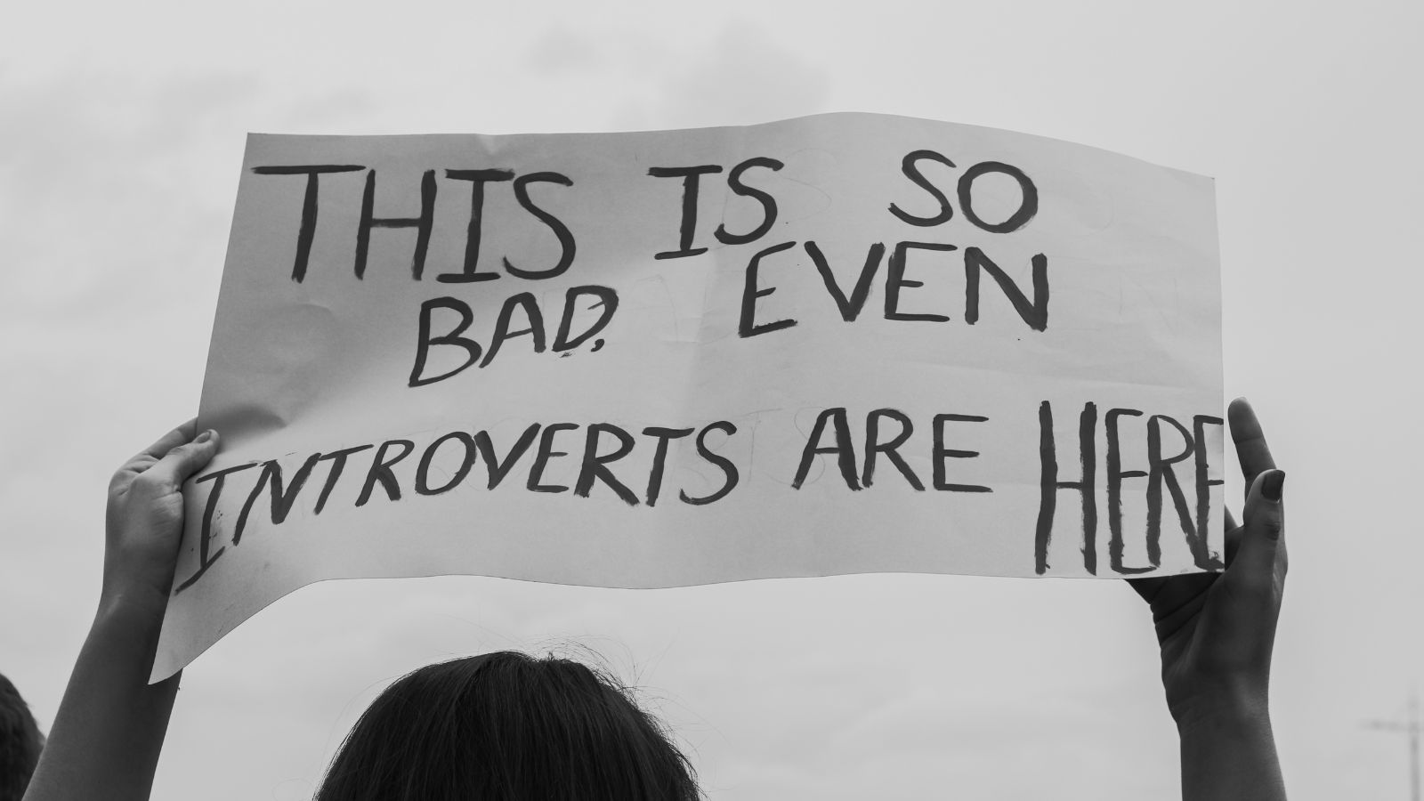 A sign saying "This is so bad even introverts are here" being held by a protester.
