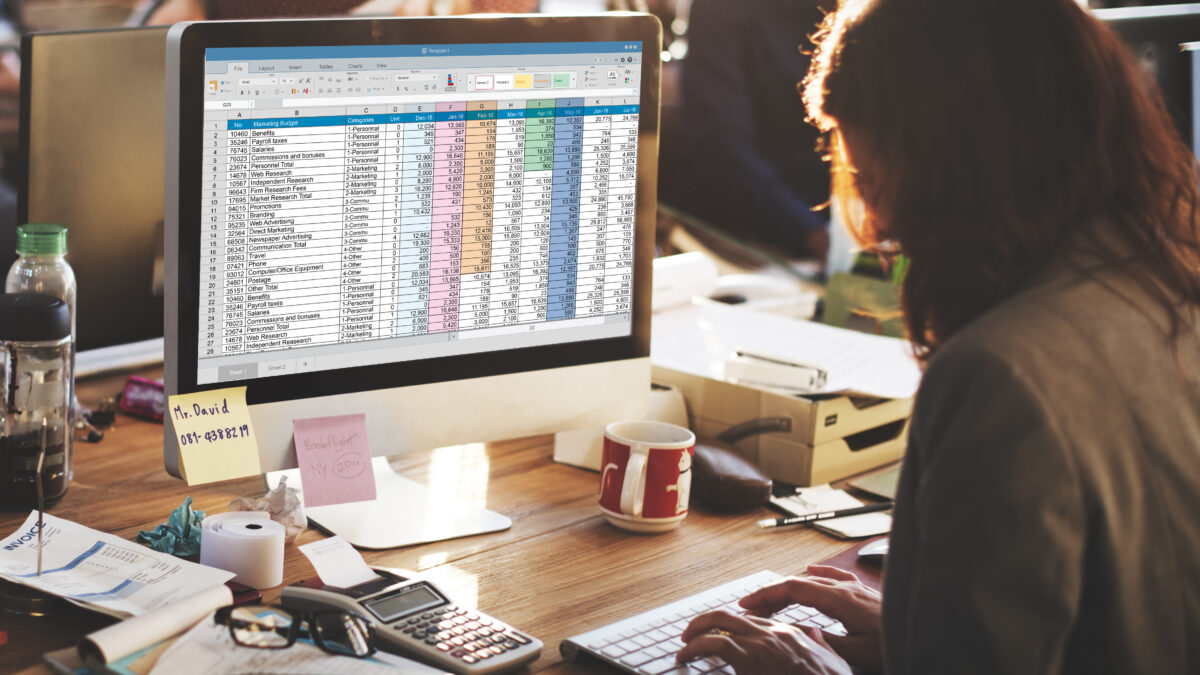 A woman working on a computer with a spreadsheet on it.