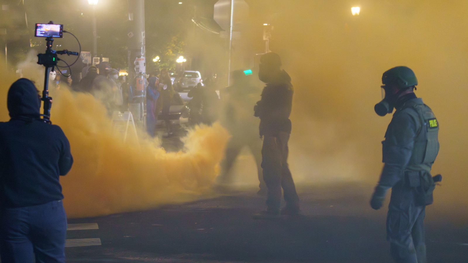 Troops standing as yellow gas floods a Portland street.