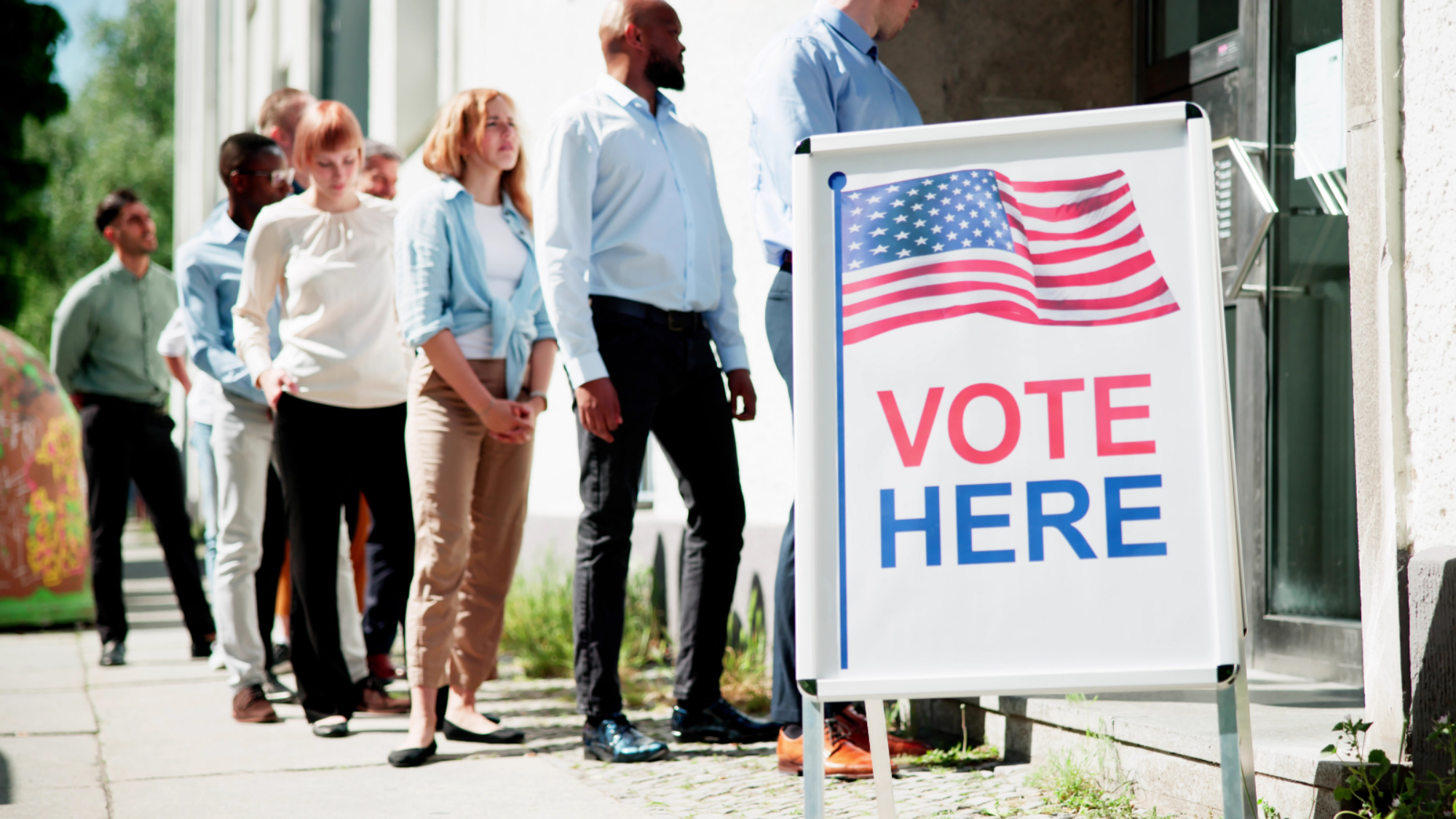 A diverse group of people in line waiting to vote.