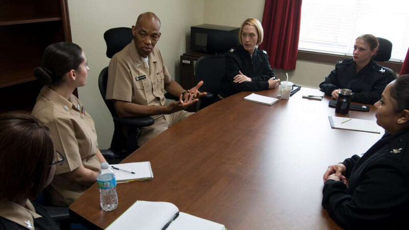 JAGs meeting around a table in a conference room.