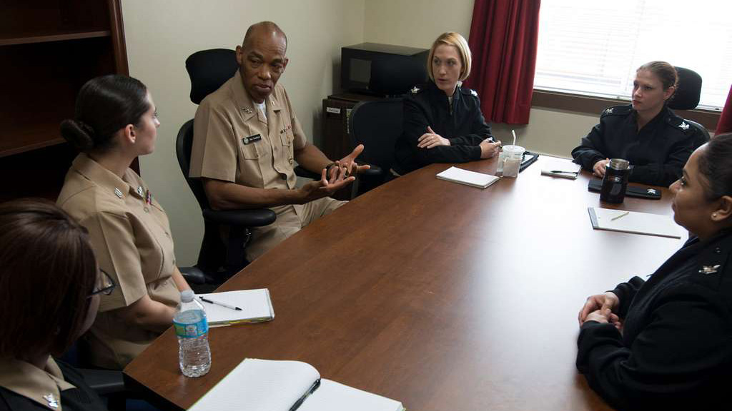JAGs meeting around a table in a conference room.