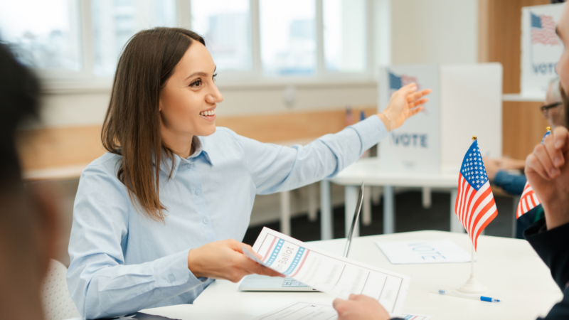 A poll worker helping people vote