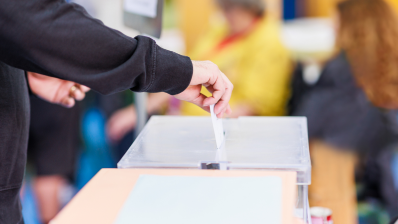 A voter putting a ballot in a box