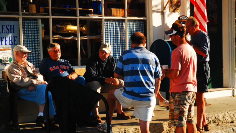 People talking with one another in Massachusetts outside a store.