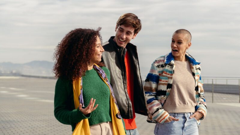 Three diverse people walking and talking outside together