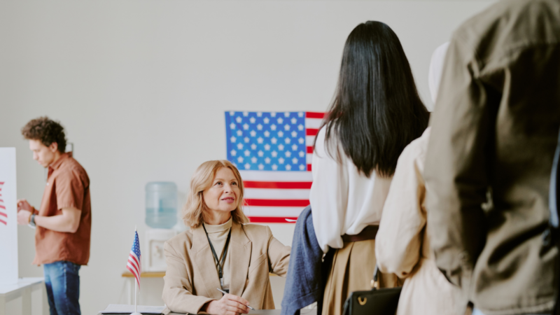 A poll worker helping people in line to vote