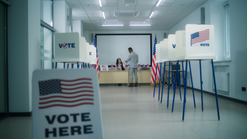 Two people talking in a polling station.
