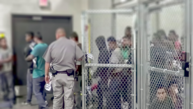 People with blurred faces being let out of an immigration cage.