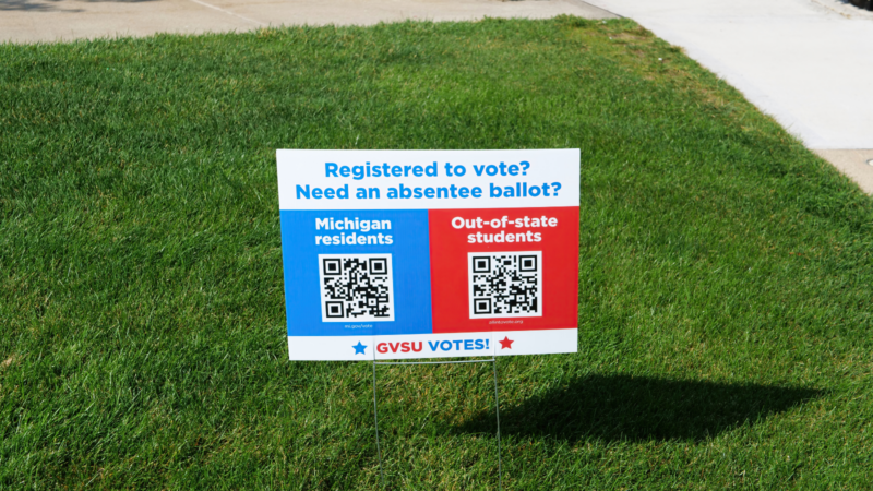 Registering to vote on campus sign with QR codes